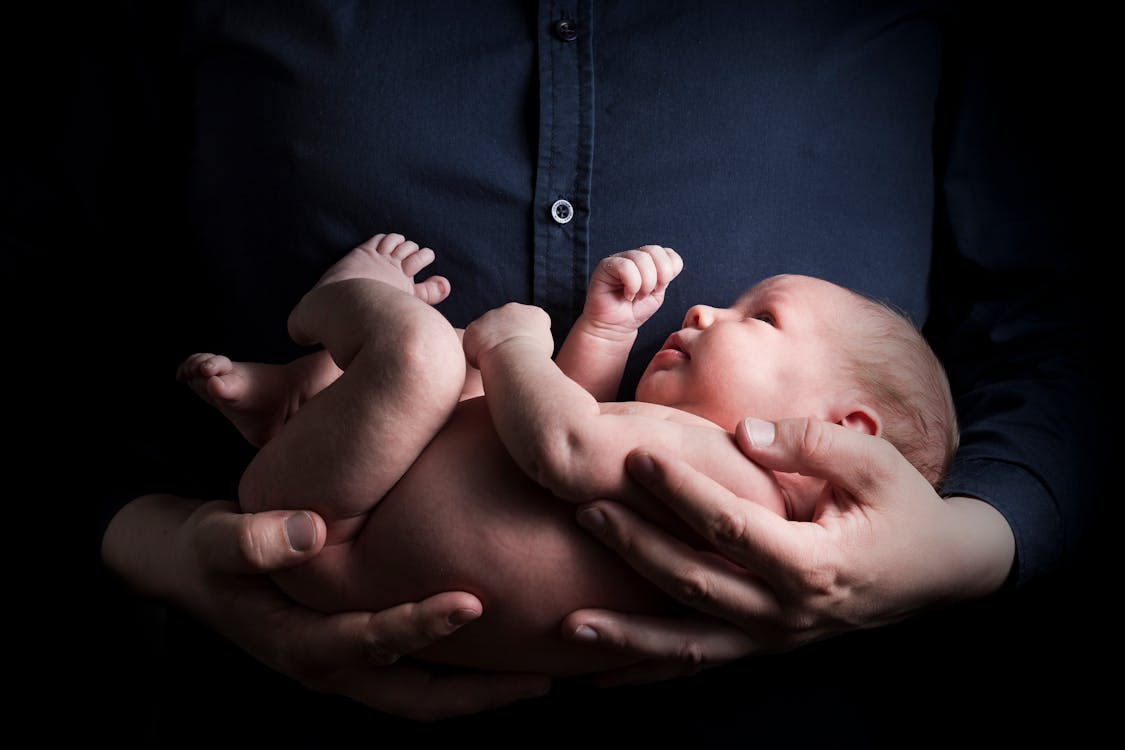 Close-Up Photo of a Person Carrying a Baby
