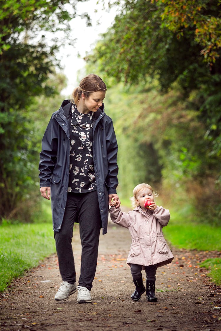 Woman Walking With Child On Pathway