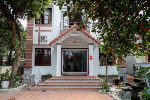 Free Contemporary house entrance with trees, showing modern design and traditional elements. Stock Photo