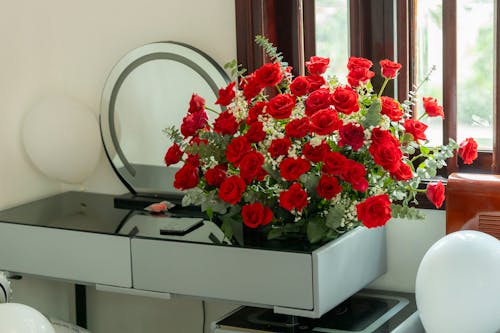 A vase of red roses sits on a table