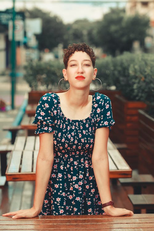 A woman with curly hair sitting on a bench