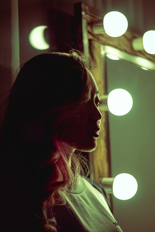 Free Woman Standing Beside Vanity Mirror With Lights Stock Photo