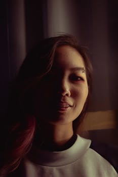 这是一张特写肖像，捕捉了一位年轻亚洲女性在变幻灯光下的独特风格