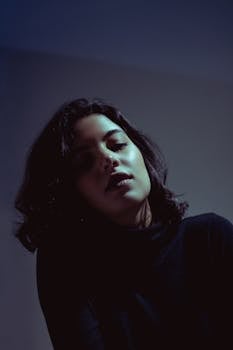 一幅女性艺术肖像，在戏剧性灯光的映衬下，营造出神秘的氛围