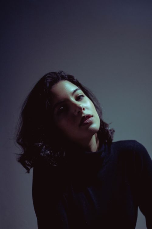 Free A dramatic portrait of a woman with dark hair in low light. Stock Photo