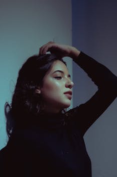 一位身着黑衣的女子，优雅地摆出姿势，在室内捕捉到深思的瞬间