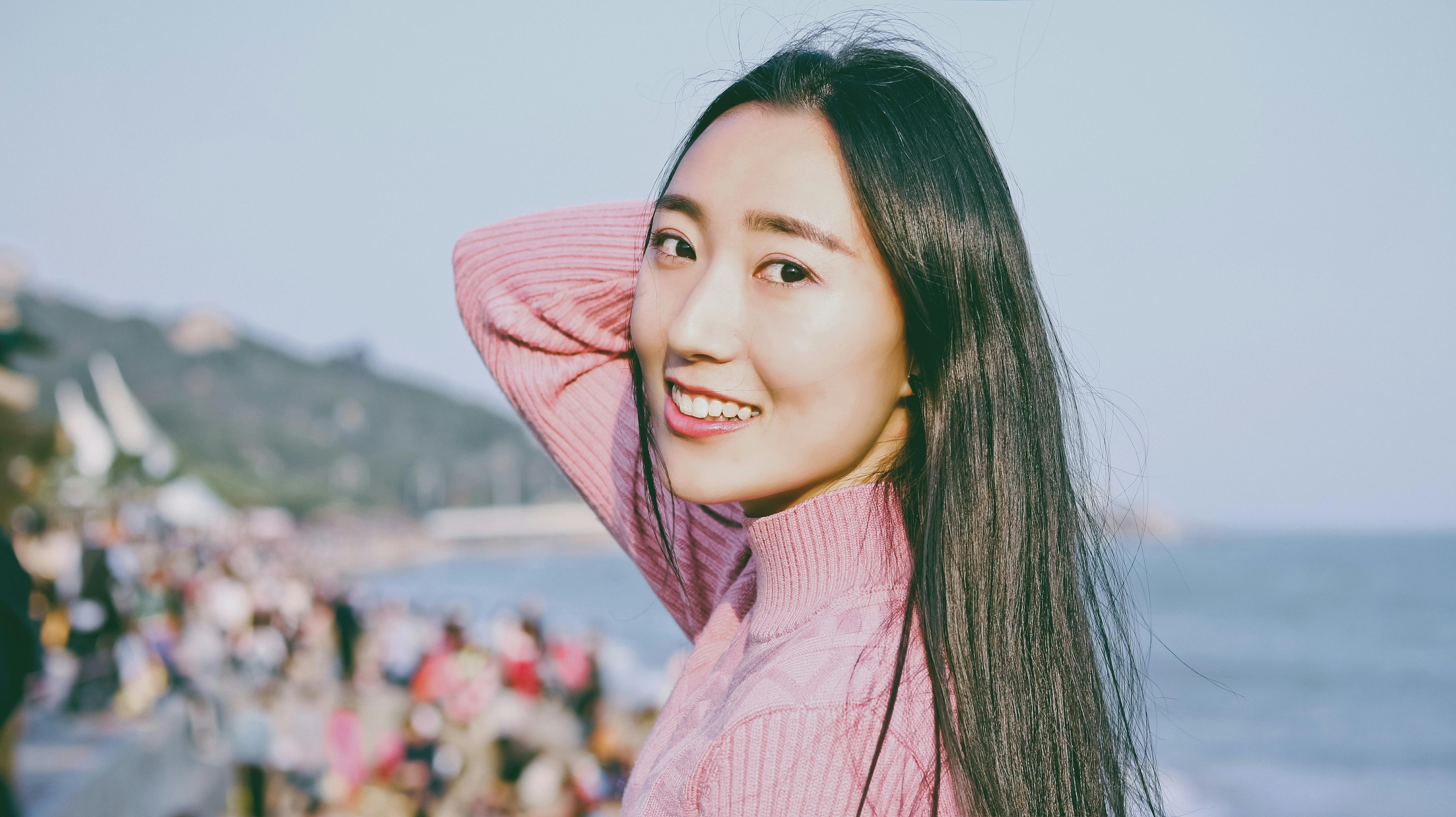 selective focus photo of smiling woman holding her hair