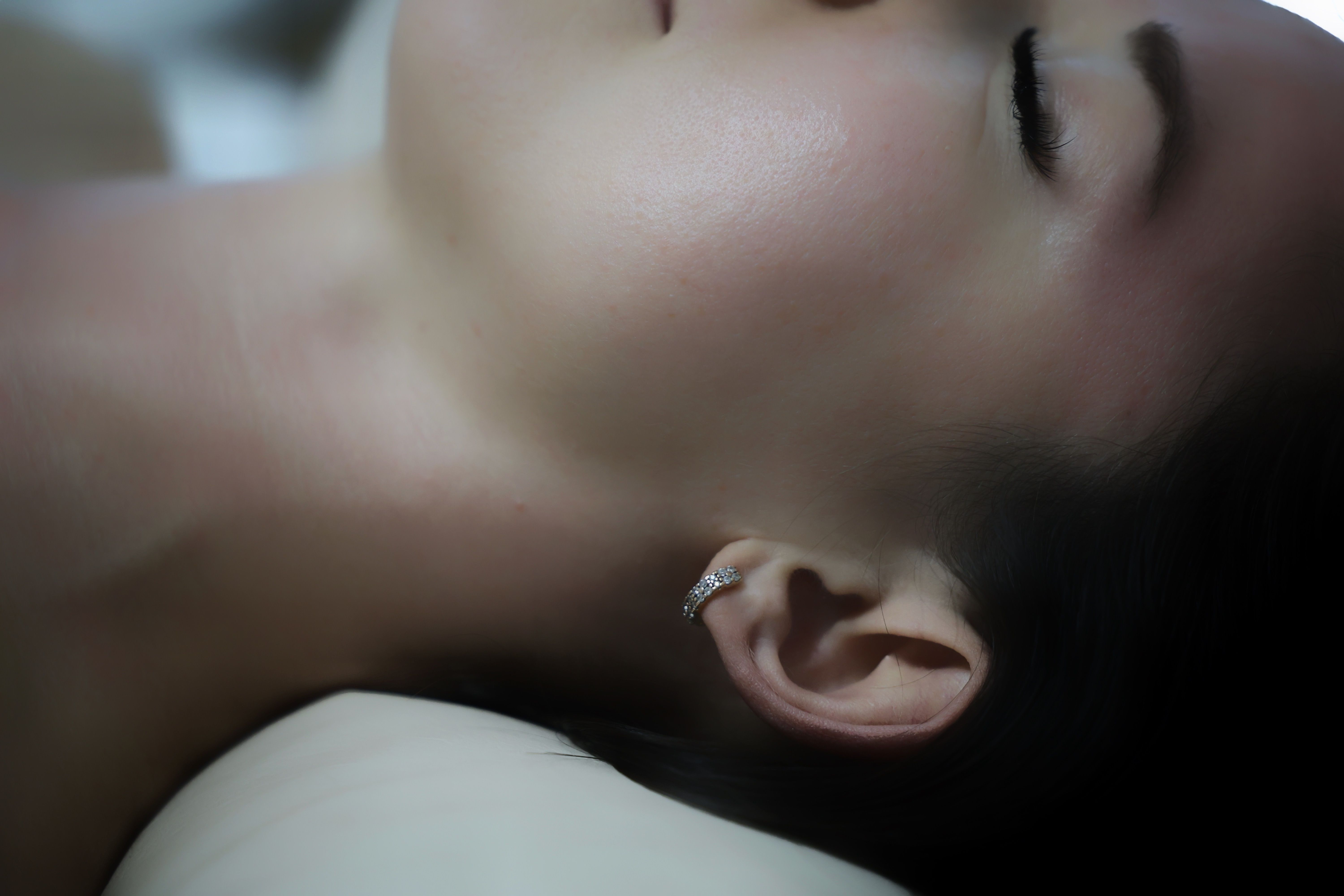 A serene close-up of a woman lying down, showcasing relaxation and elegance.