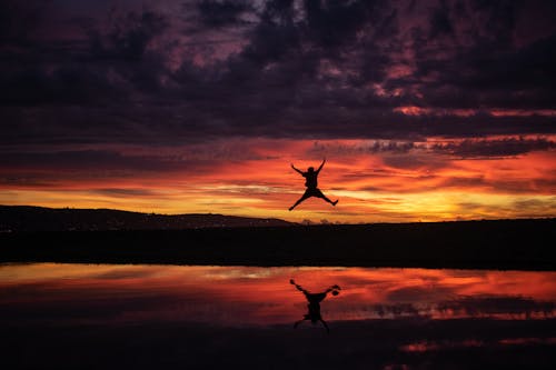 Free Man Jumping during Golden Hour Stock Photo