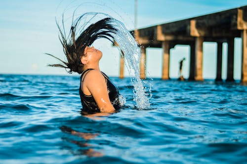 Fotografi Time Lapse Seorang Wanita Membalik Rambutnya Saat Mandi Di Laut