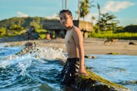 热带海滩旁，青苔覆盖的岩石边，海浪汹涌