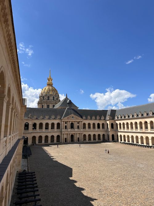 Free View of the historic courtyard and dome of Les Invalides in Paris under blue sky. Stock Photo