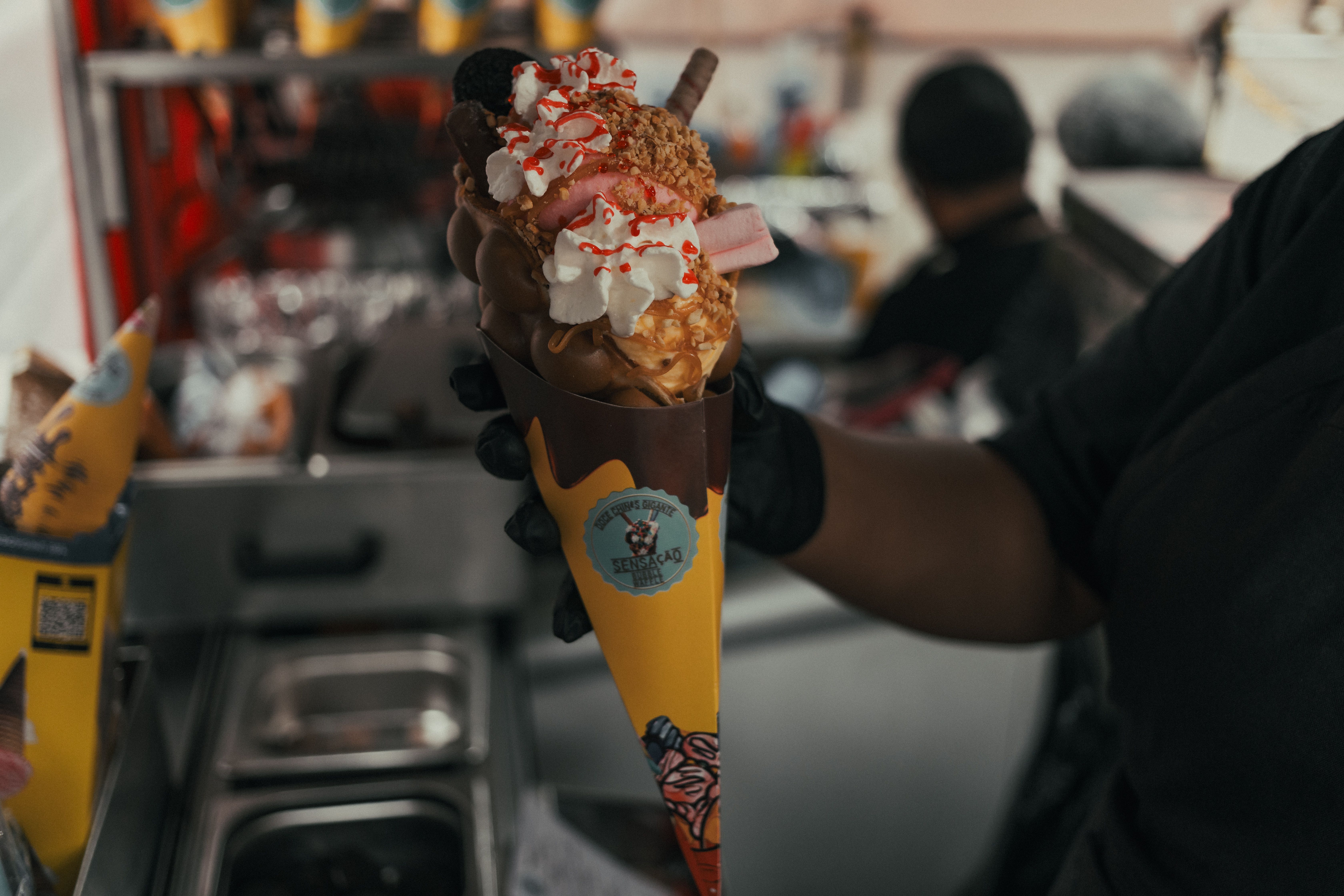 miso caramel ice cream cone with flakes of sea salt against a dark background