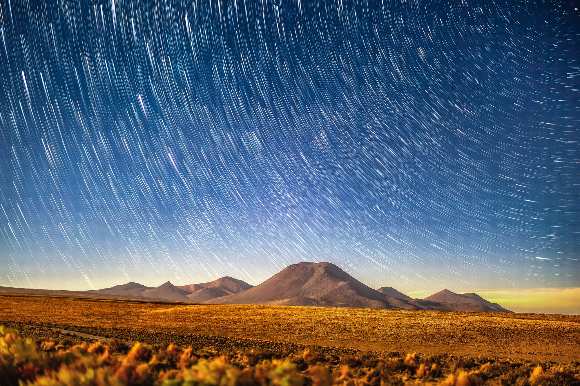 Stunning long exposure of star trails over a mountain range.