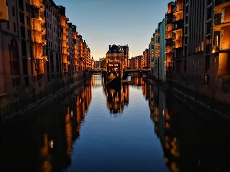 Captivating evening view of the illuminated Speicherstadt canal in Hamburg, Germany, reflecting dazzling lights. by Christian Richert