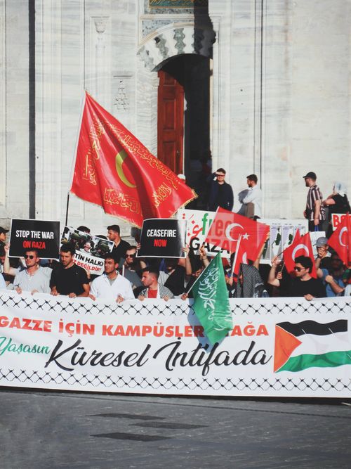 Free Large group protesting for peace and ceasefire in front of a historic building. Stock Photo