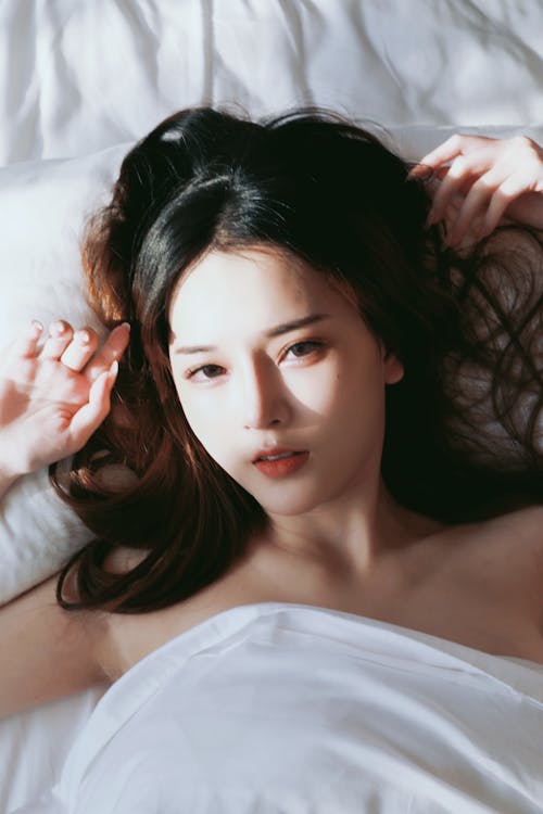 A woman laying in bed with her hair down