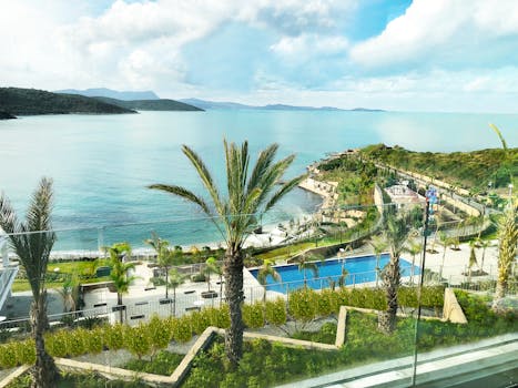 Scenic ocean view from a Bodrum resort showcasing palm trees and a relaxing atmosphere.