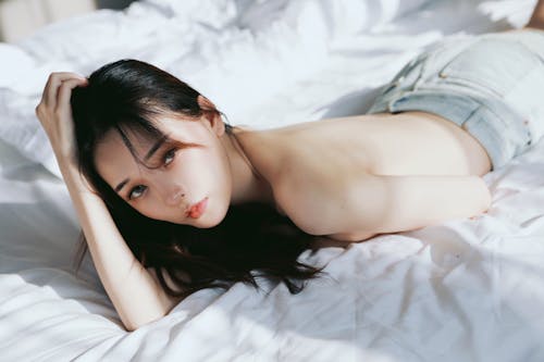 A woman laying on a bed with her hair down