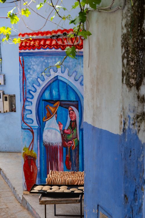 Free Vibrant street mural depicting Moroccan culture with freshly baked bread on display. Stock Photo