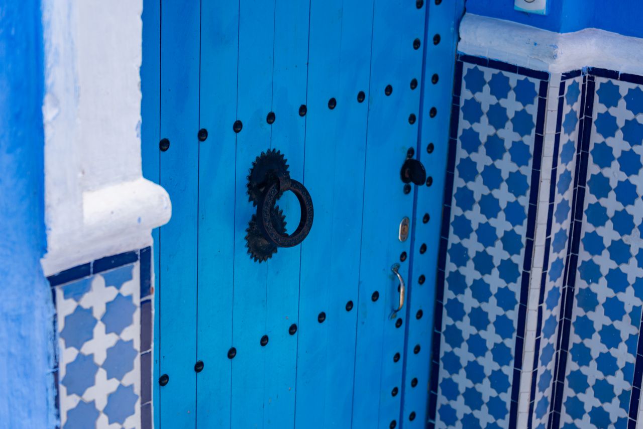 a vibrant blue wooden door with traditional ornate patterns and geomet