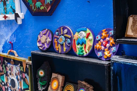 Vibrant display of handmade Mexican wall art with ceramic and wooden elements.