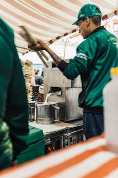 A street vendor prepares fresh juice at an outdoor food market, showcasing urban culinary culture.