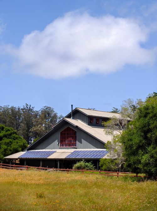 Free Rustic barn with solar panels amidst a lush rural landscape, highlighting sustainable agriculture. Stock Photo