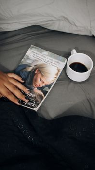 A cozy scene featuring a morning cup of coffee and a book in bed, perfect for relaxation.
