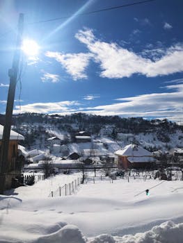 冬日里，白雪皑皑的村庄风景如画，天空蔚蓝，阳光明媚