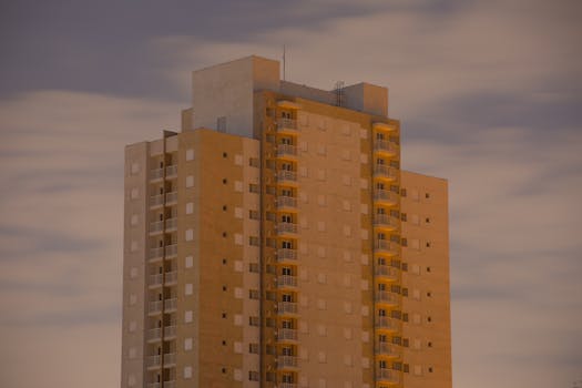 Captivating view of a modern high-rise with glass balconies during twilight hours.
