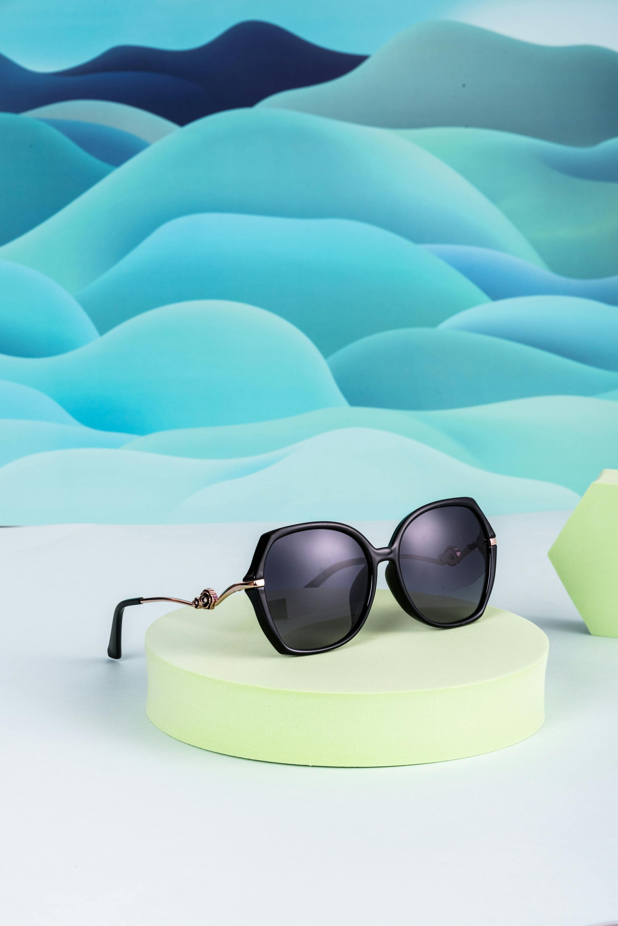 Chic sunglasses on a pastel stand with abstract blue background. Modern fashion accessory.