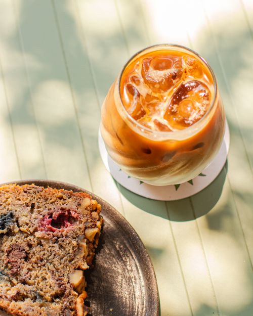 Free Iced coffee and cake slice on a sunlit table in Oaxaca, perfect for summer refreshment. Stock Photo