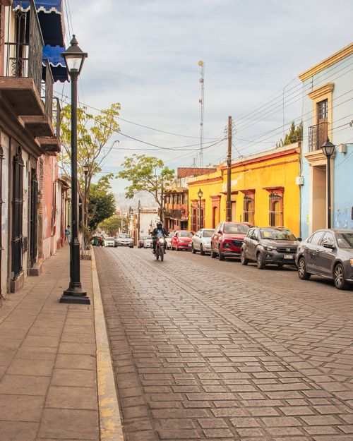 Free A vibrant street in Oaxaca city showing local architecture and bustling life. Stock Photo