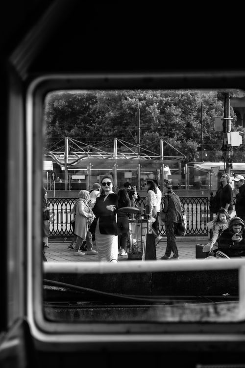 Free Black and white photo capturing a bustling crowd through a window at a train station. Stock Photo