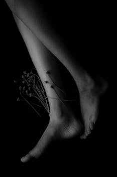 艺术构图中的黑白照片优雅地突出了修长的双腿和精致的花朵