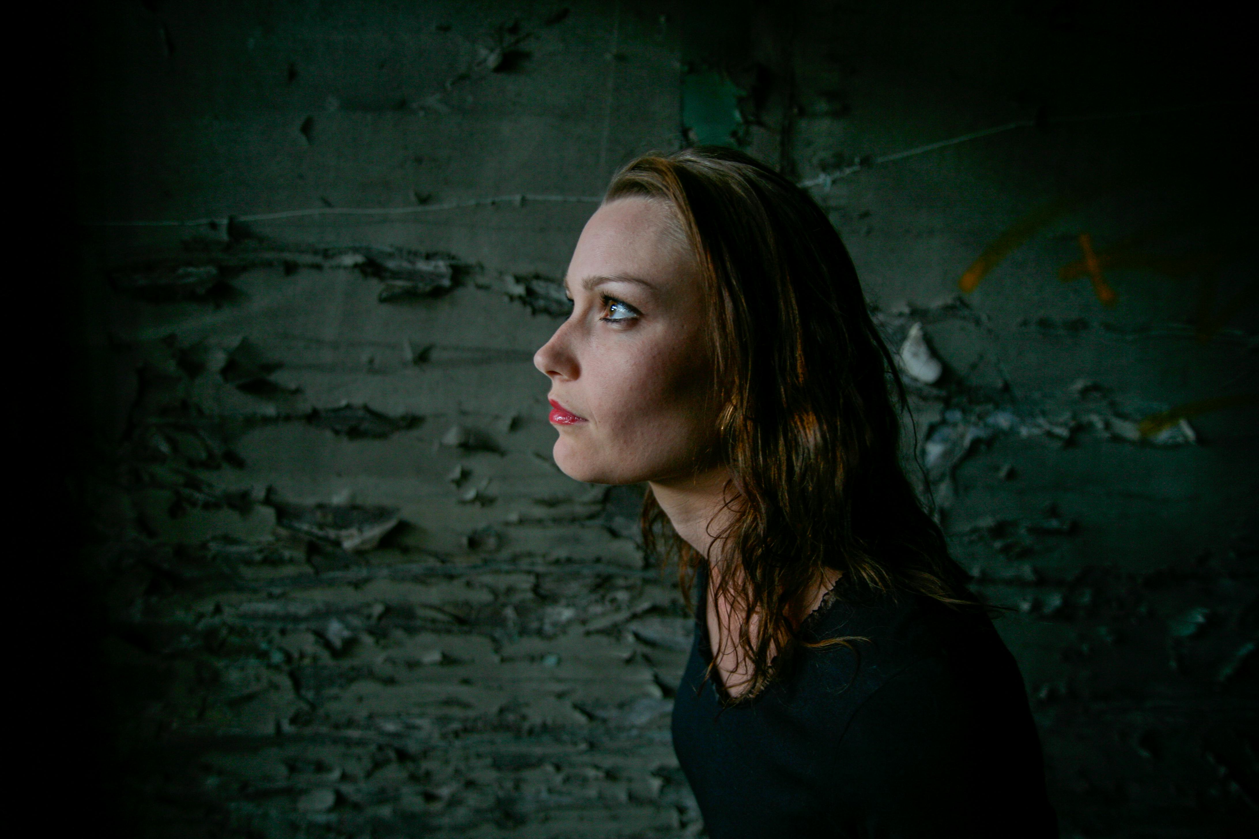 一幅女性艺术肖像，背景富有戏剧性