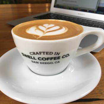 A close-up of a cappuccino with latte art in a stylish ceramic cup at a San Diego cafe.