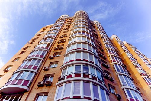 Free Low angle view of a modern high-rise building in Kyiv, featuring glass windows against a clear blue sky. Stock Photo