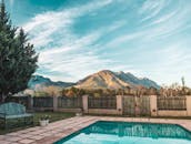 这座别墅坐落在泳池边，以山脉为背景，优雅而奢华，非常适合度假