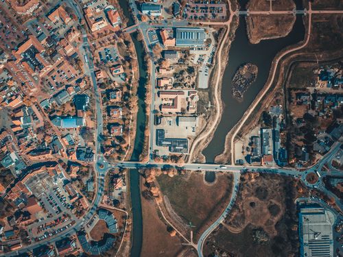 Free Aerial shot capturing the intricate city layout with roads, buildings, and a body of water. Stock Photo