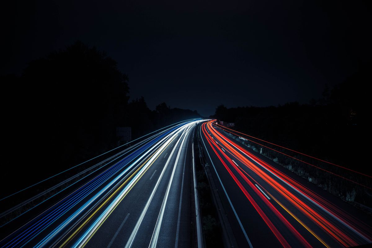 Autostradă europeană cu vehicule în mișcare și lumini de noapte