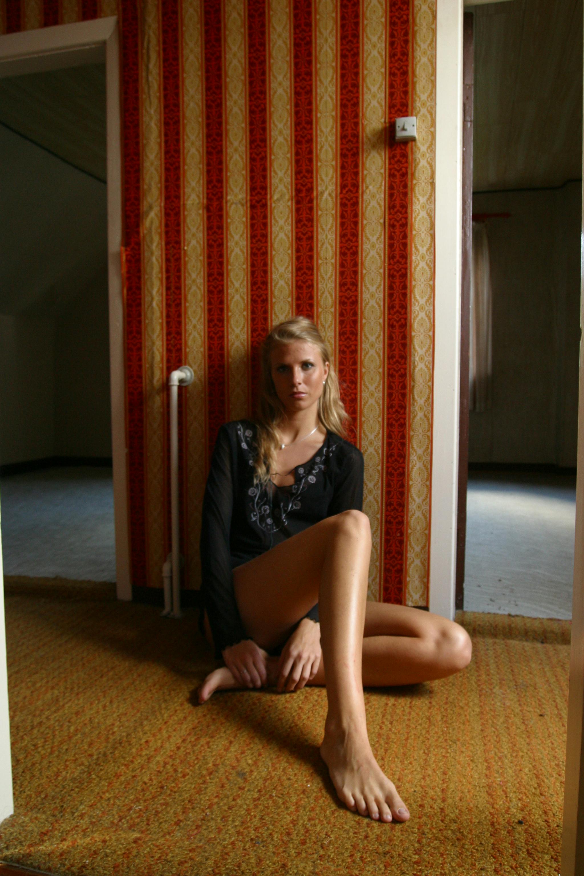 一位时尚女士在一间壁纸带有图案、氛围温暖的复古房间里摆姿势