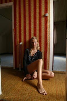 一位时尚女士在一间壁纸带有图案、氛围温暖的复古房间里摆姿势