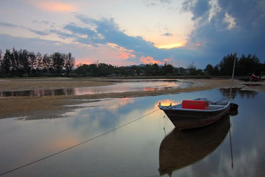 日落时分，一艘渔船停在宁静的湖面上，倒映着充满活力的天空