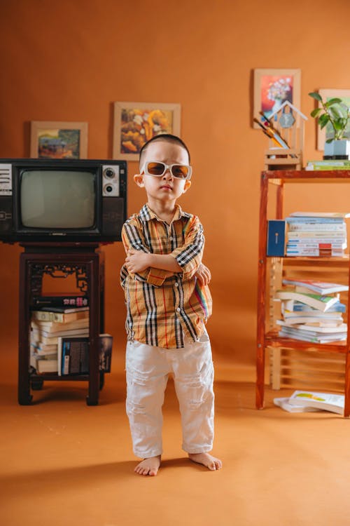 A child standing in front of a television with a book