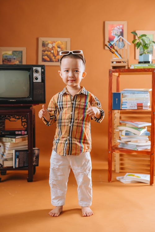 A young boy standing in front of a television