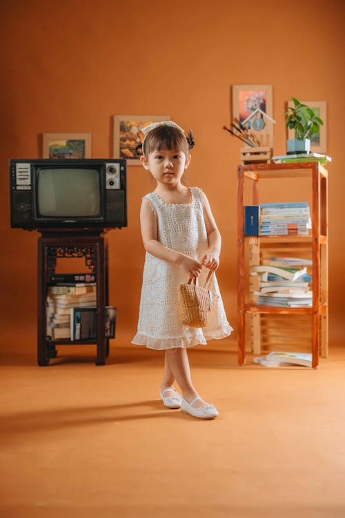A little girl standing in front of a tv