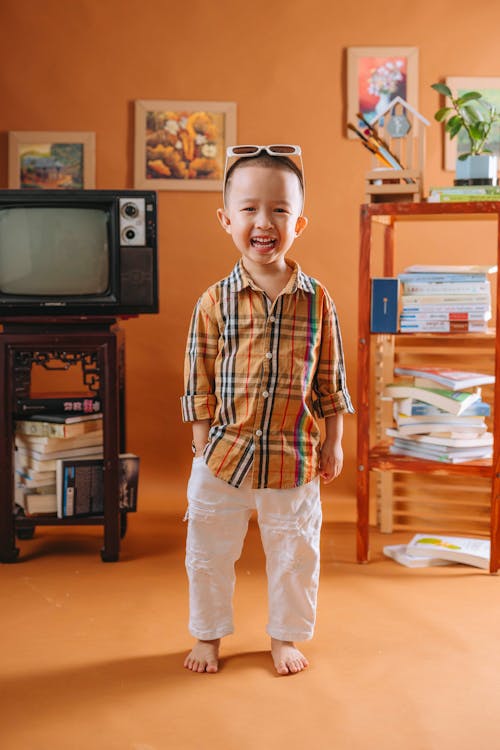 A little boy standing in front of a television