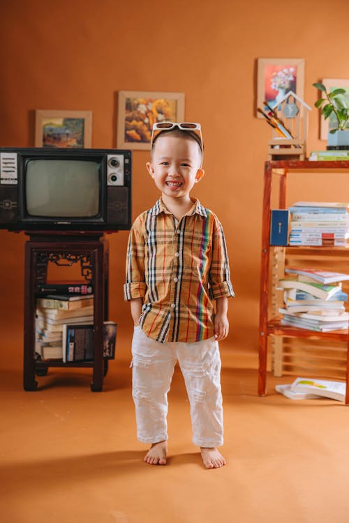 A little boy standing in front of a television